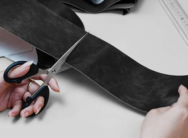Cutting the leather repair sheet to size with scissors